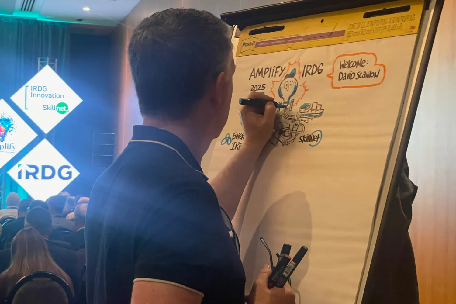A member working through a framework on a large sheet at an IRDG session while others follow.