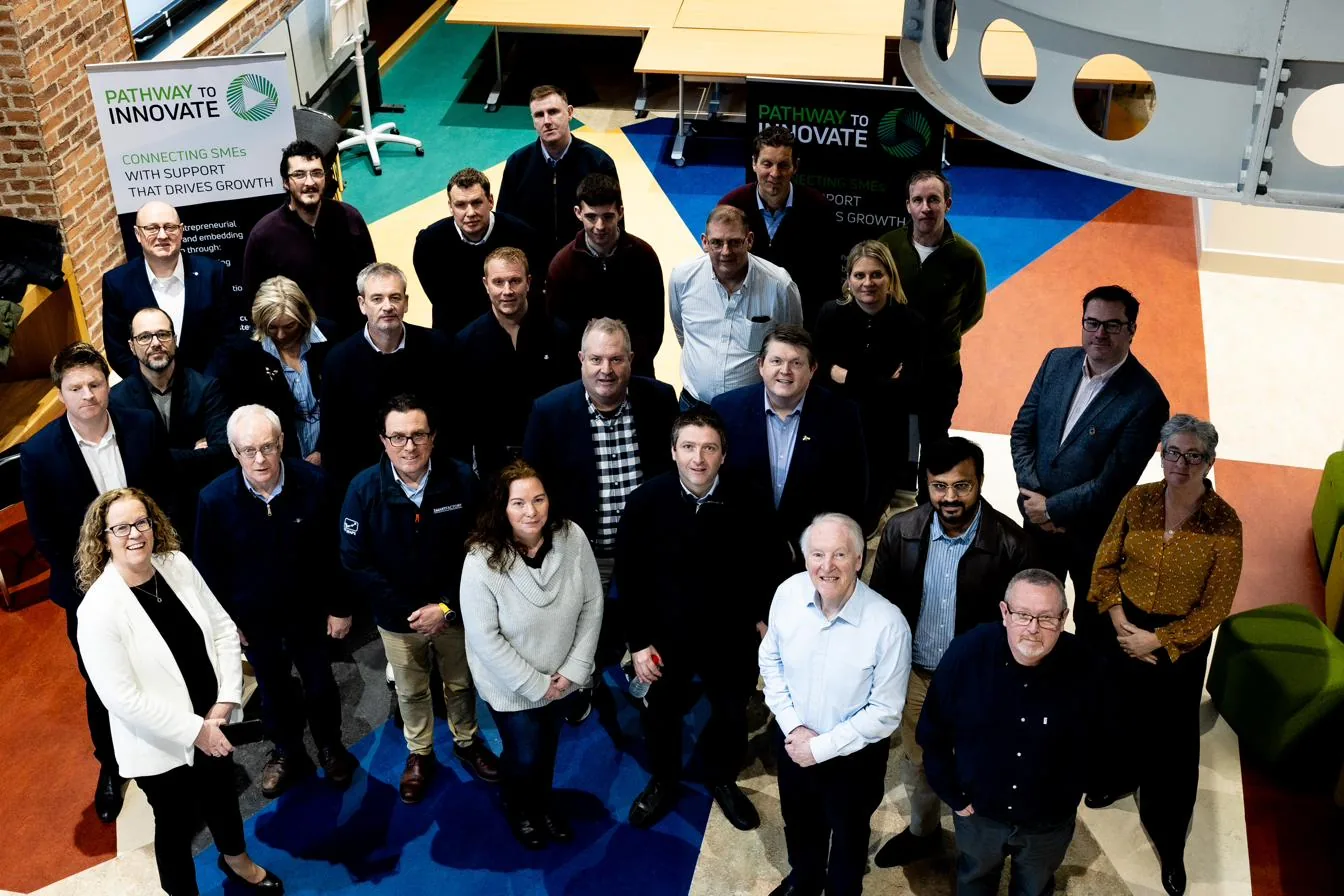 A Pathway to Innovate cohort — around thirty owner-managers and their trainers standing together in a training room, the programme banner behind them.